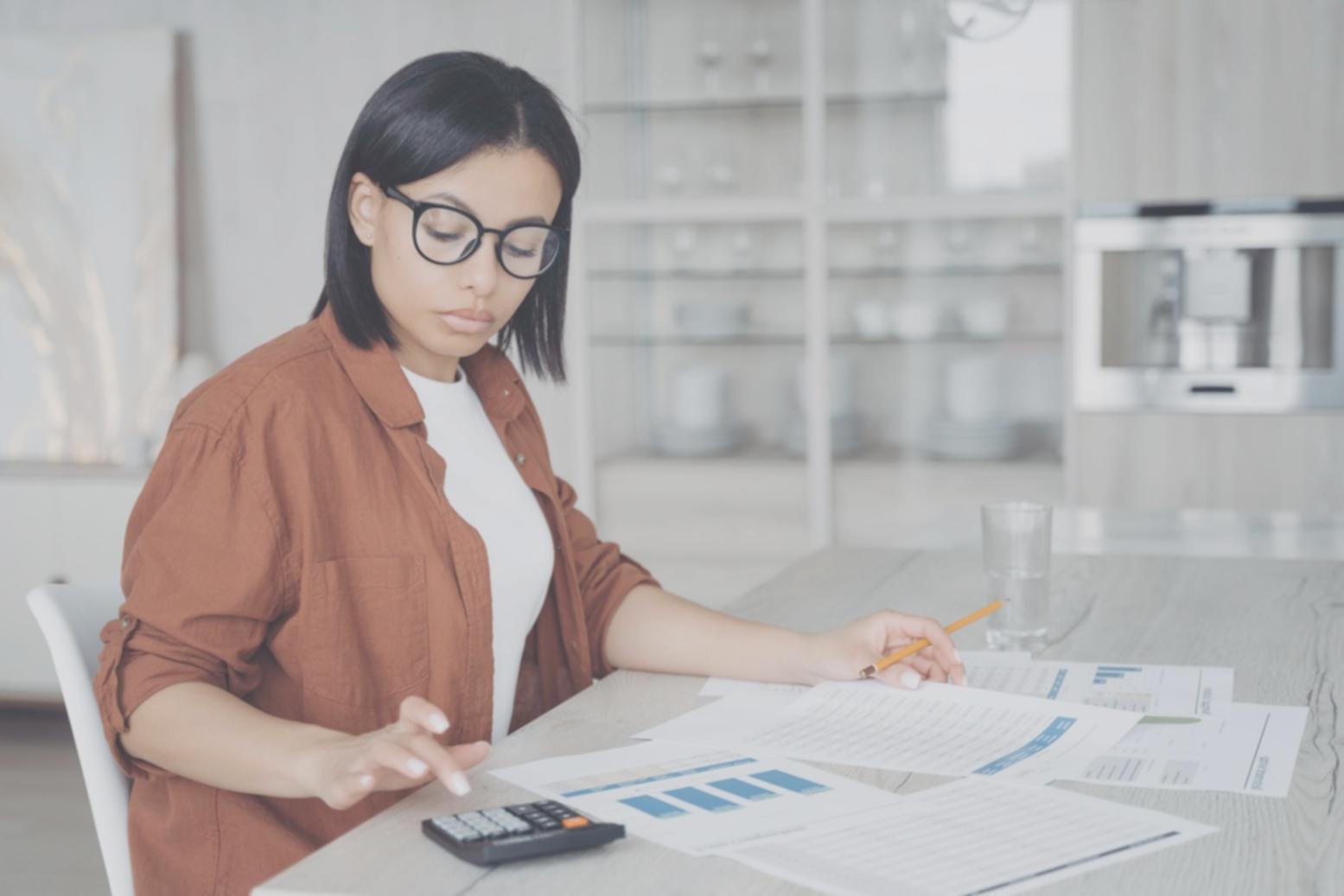 Sesión de análisis financiero con documentos y calculadora sobre mesa de trabajo